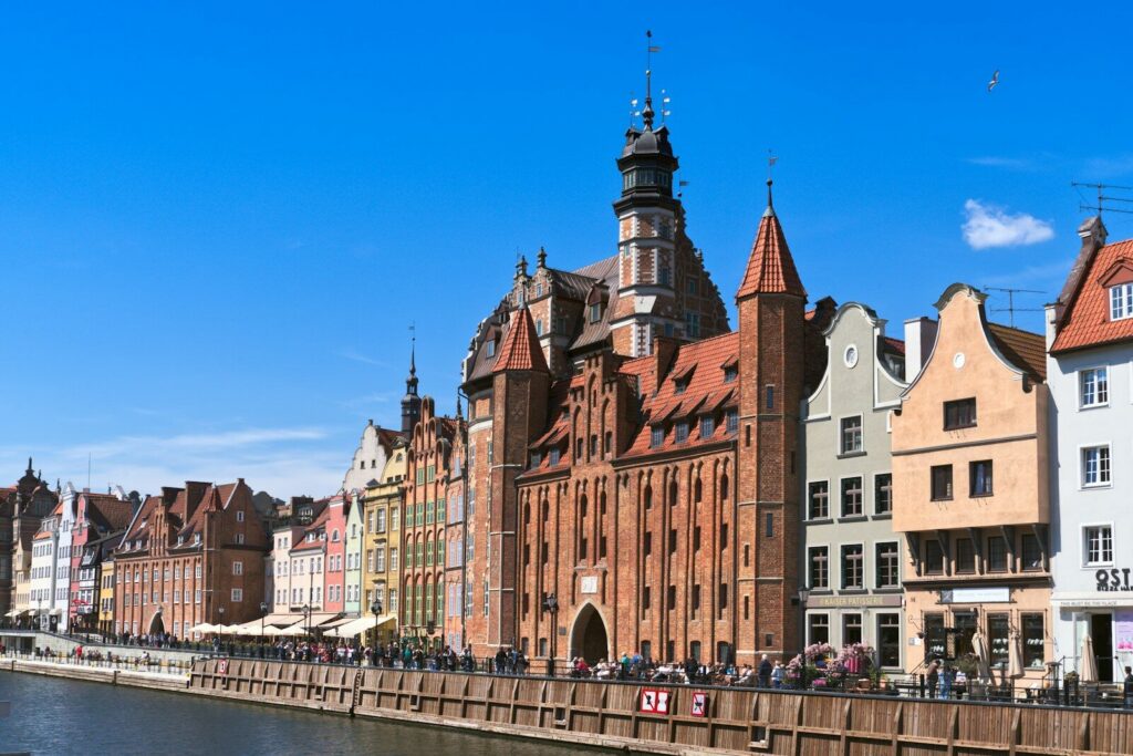 Colorful historic buildings line a waterfront under a blue sky